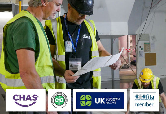 Two construction workers in high-visibility vests reviewing plans with a third worker in a hard hat, featuring CHAS, CPD, UK Sustainable Construction Alliance, and FITA logos.